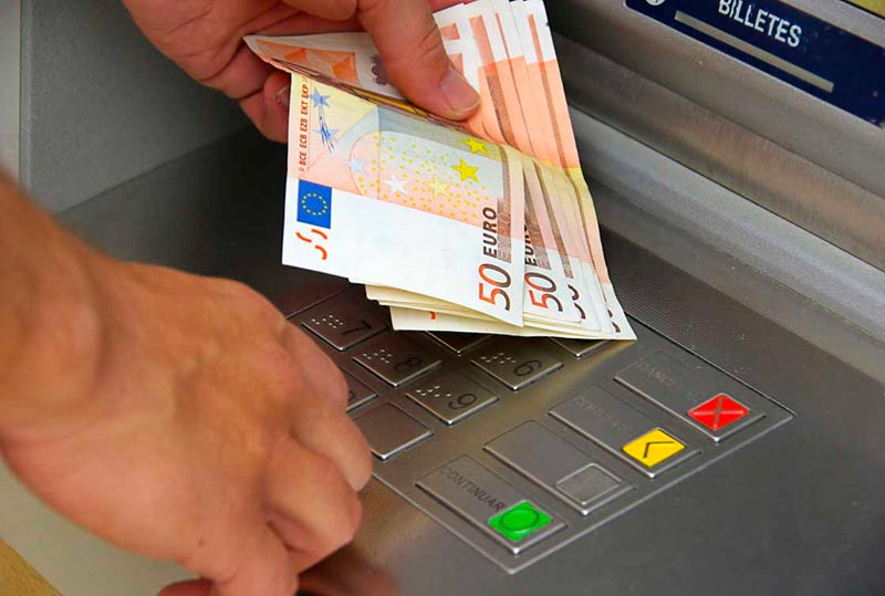 Un usuario retira dinero de un cajero automático. (Archivo)