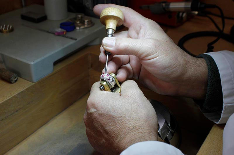 Martín Constantino engastando un anillo de oro blanco de 18 quilates con diamantes y zafiros rosas.
