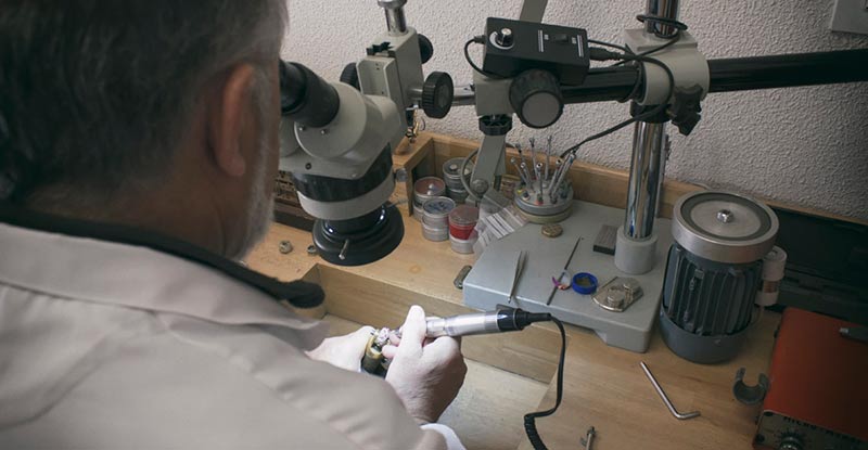 Martín Constantino engastando un anillo de oro blanco de 18 quilates con diamantes y zafiros rosas.