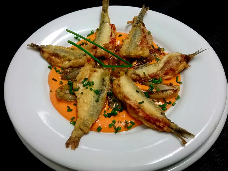 Anchoas sobre crema de pimientos.