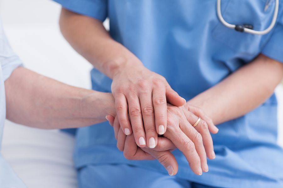 Una enfermera coge la mano de un paciente. 