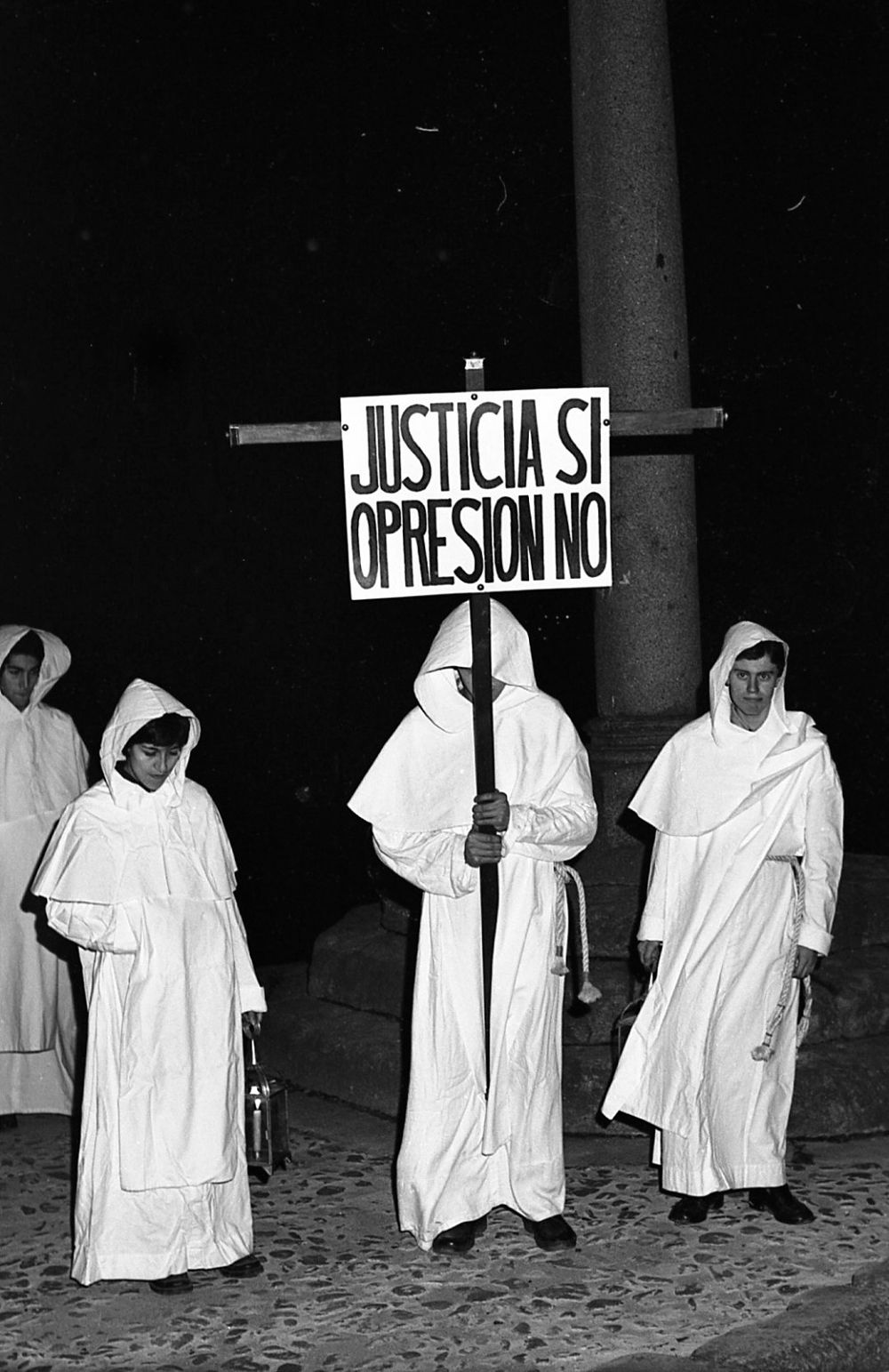 Hermandad de Amor y Paz / ICAL. Medio siglo de la hermandad que revitalizó la Pasión salmantina. Los hermanos de Amor y Paz sacaban en la procesión pancartas con frases extraídas de La Biblia.