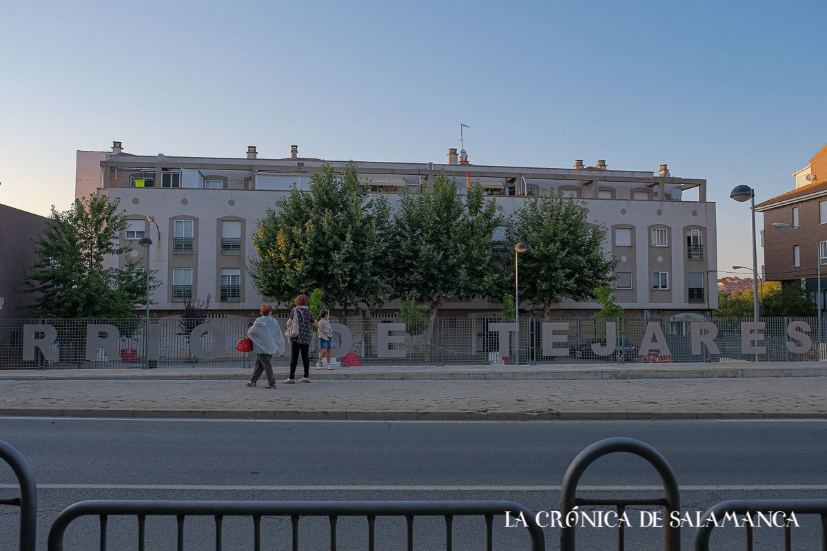 Tres personas pasean cerca del antiguo frontón de Tejares. Tres personas pasean cerca del antiguo frontón de Tejares.