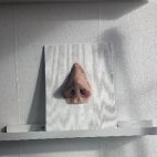 Una escultura de una nariz sobre una pared.