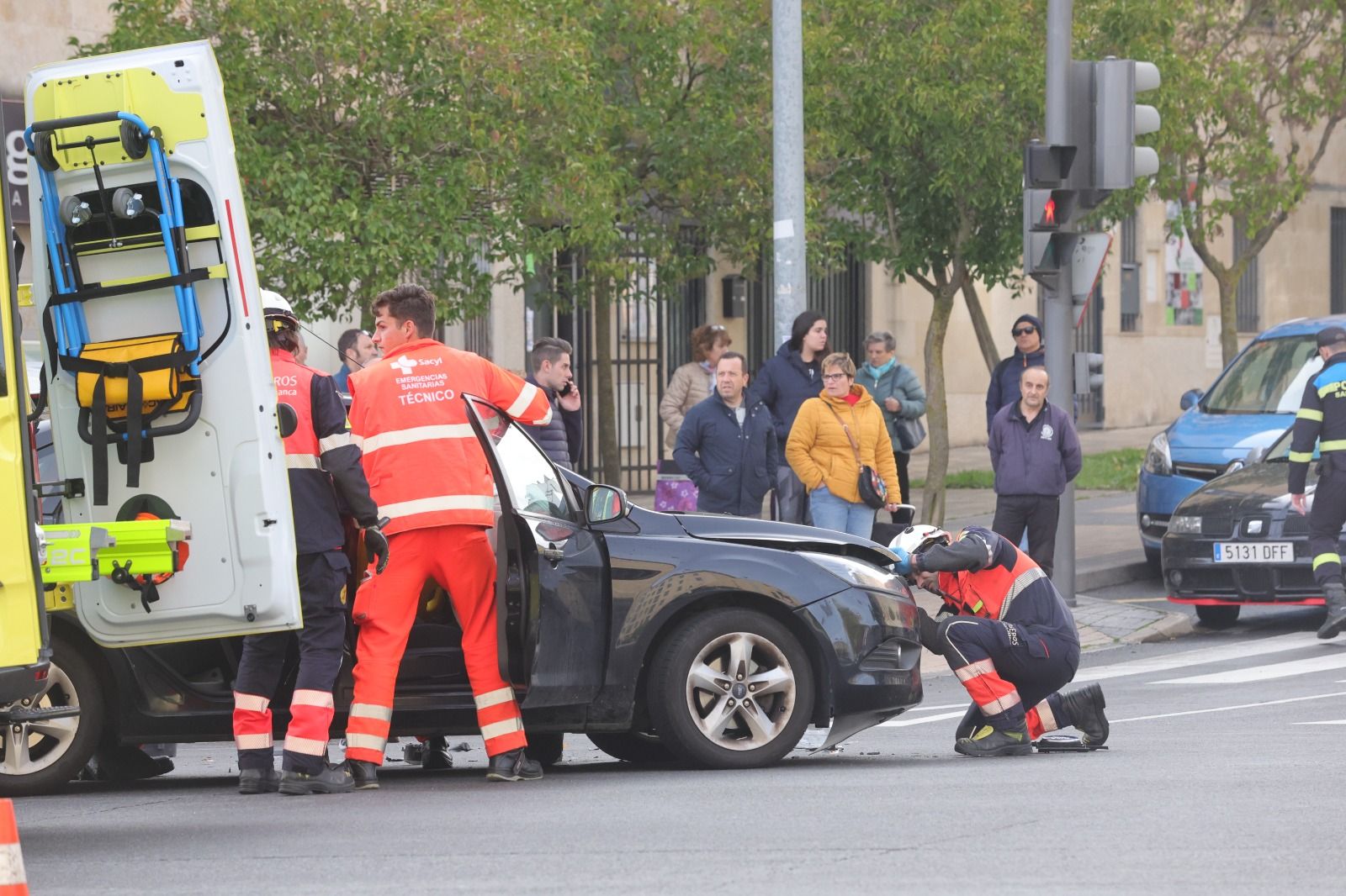 Personal sanitario y bomberos auxilian a la mujer herida y atrapada en su vehículo. 
