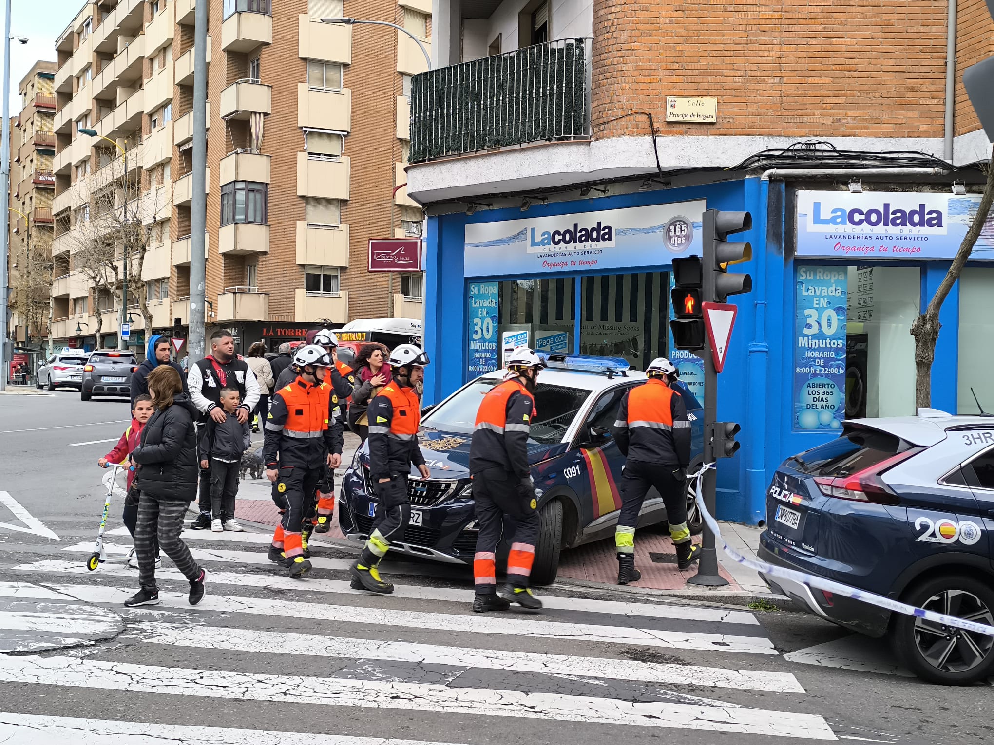 Bomberos y policías nacionales en la calle Príncipe de Vergara. 