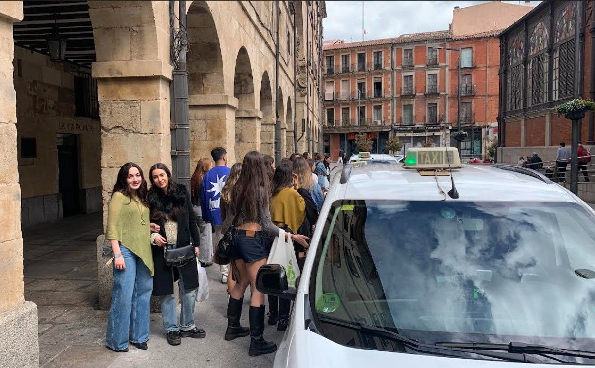 Un grupo de jóvenes coge un taxi en la Plaza del Mercado.