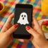 Un teléfono móvil, con un fantasma en su pantalla. Imagen de IA | ChatGPT.