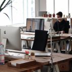 Una persona trabajando en una oficina y otras mesas vacías. Imagen de StockSnap en Pixabay