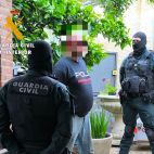 Dos guardias civiles custodian al detenido en Cepeda.