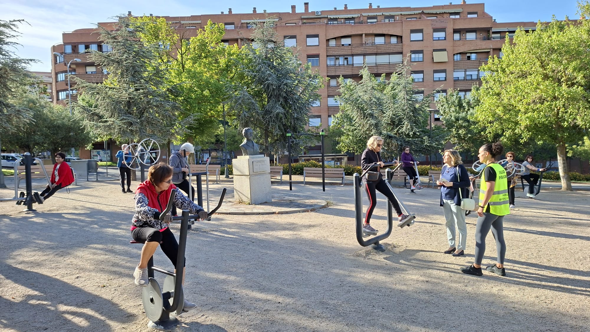 Personas haciendo ejercicio guiado por un profesional en el parque biosaludable Villar y Macías. 