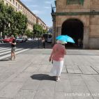 Una mujer se protege del sol, en la primera ola calor del verano, en junio