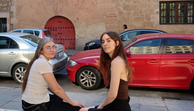 Ana Garriga y Carmen Urbita son las autoras de ‘Instrucciones de novicia’ y del podcast ‘Las hijas de Felipe’, con la casa de Santa Teresa en Salamanca al fondo.