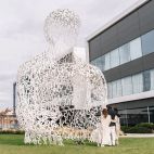 Los tres hijos de Isak Andic, junto a la estatua dedicada a su padre en la sede de Mango. 