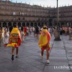Dos jóvenes con dos banderas de España muy diferentes entrando en la Plaza Mayor. 