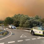 Patrullas de la Guardia Civil en los cruces de carretera con el incendio al fondo.