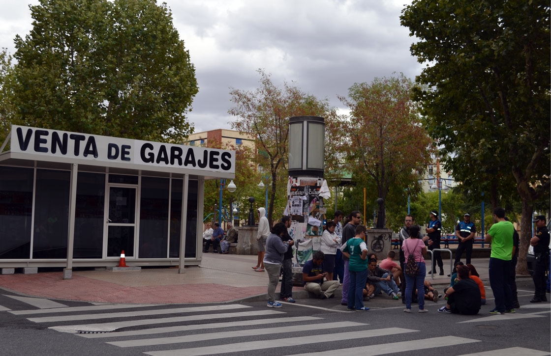 sentada en garrido contra el parking