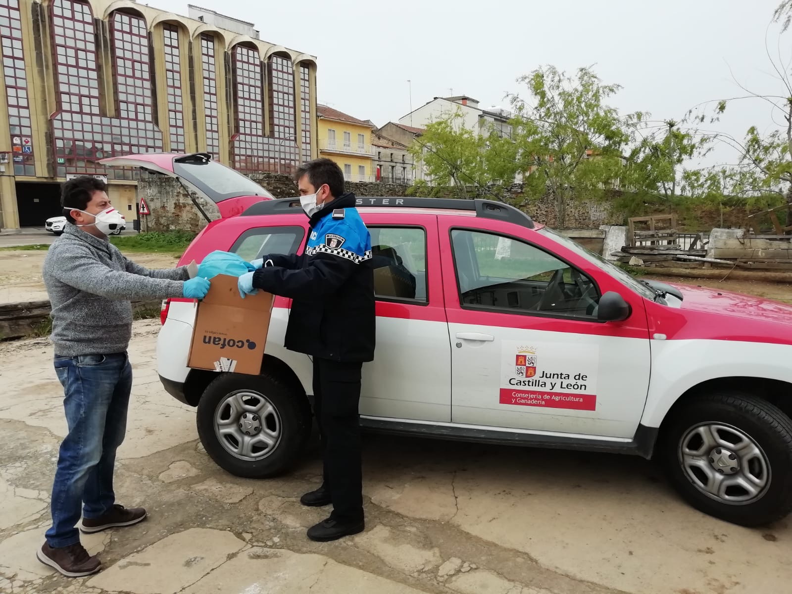 Policía Local de Guijuelo entrega los dispensadores a un técnico de la Junta de Castilla y León.