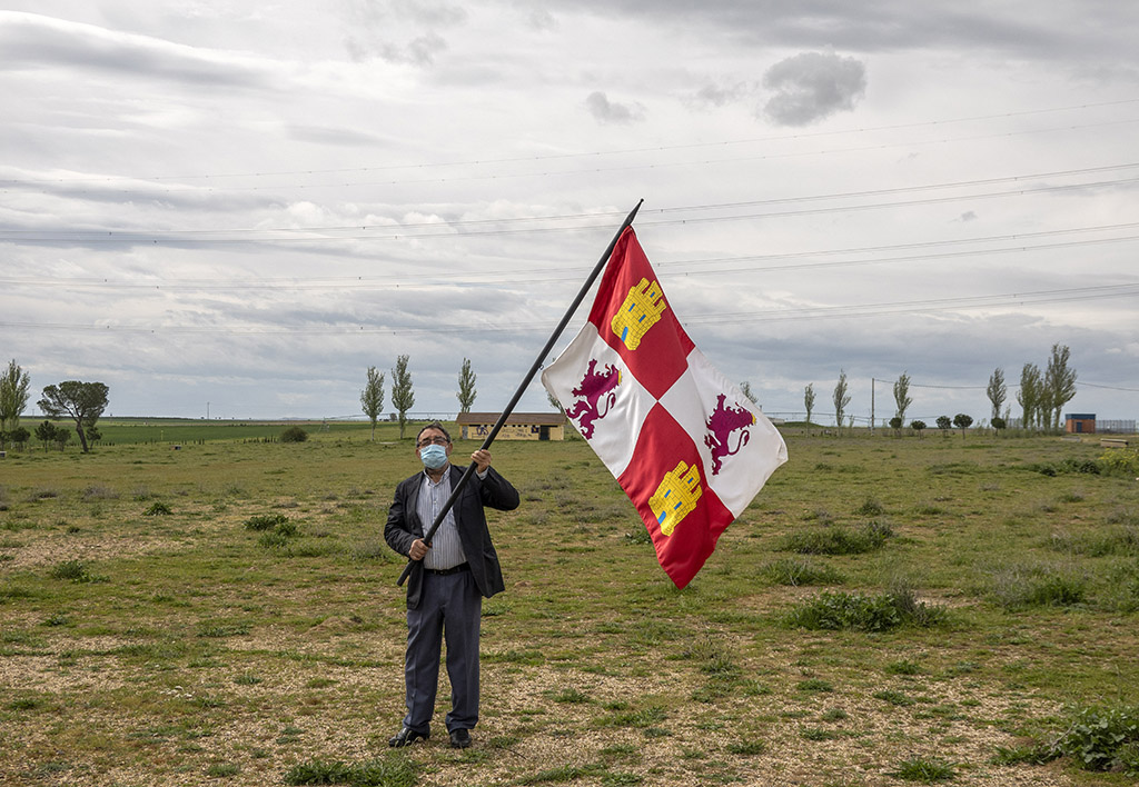 Eduardo Margareto / ICAL. El alcalde de Villalar, Luis Alonso, pasea por la campa vacía de Villalar con una bandera de Castilla y León