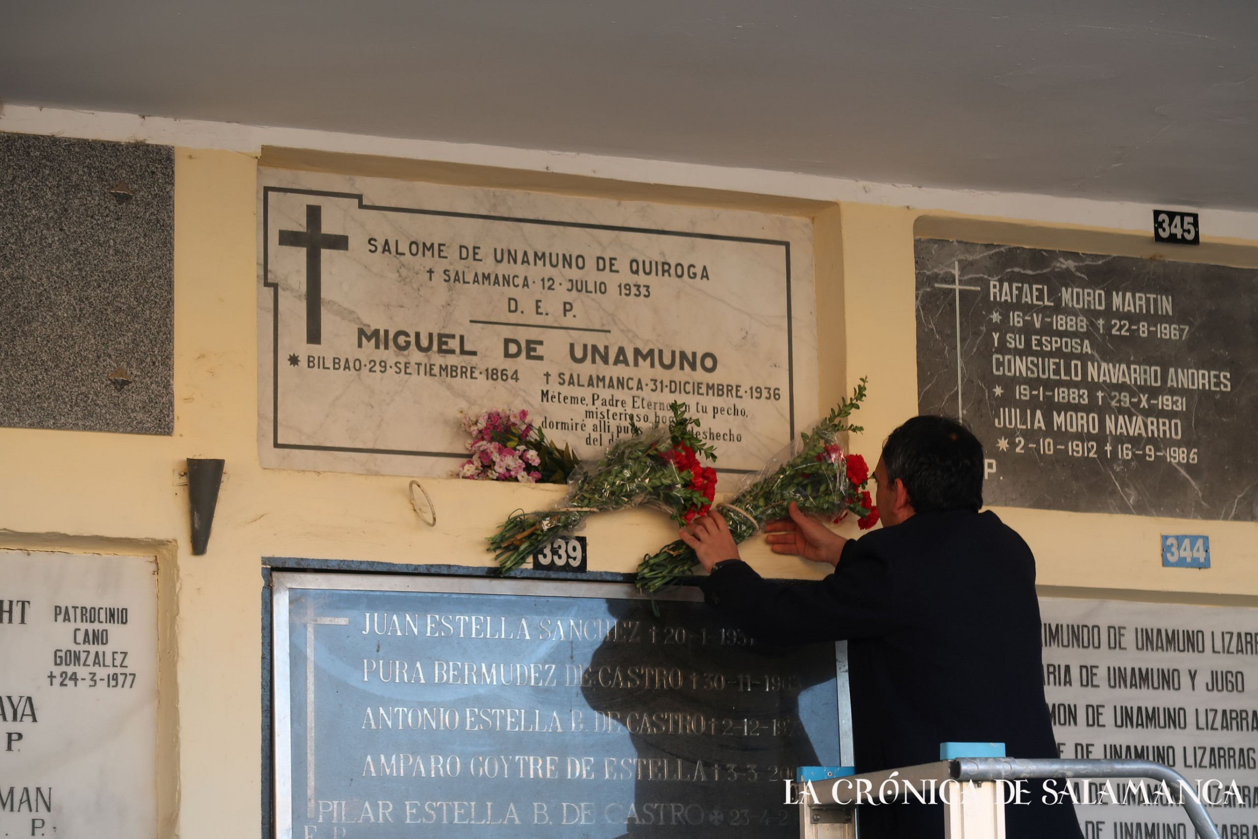 El periodista Francisco Gómez coloca dos ramos de flores en la lápida de Miguel de Unamuno.