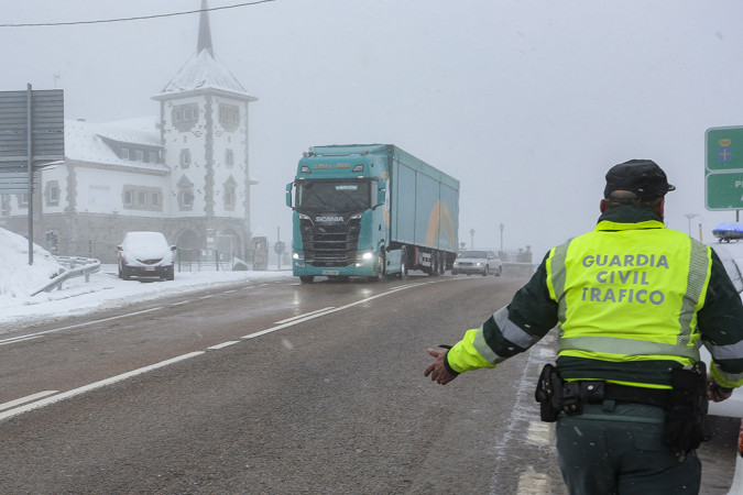 Campillo / ICAL . Un guardia civil de tráfico y un camión en el Puerto de Pajares (León)