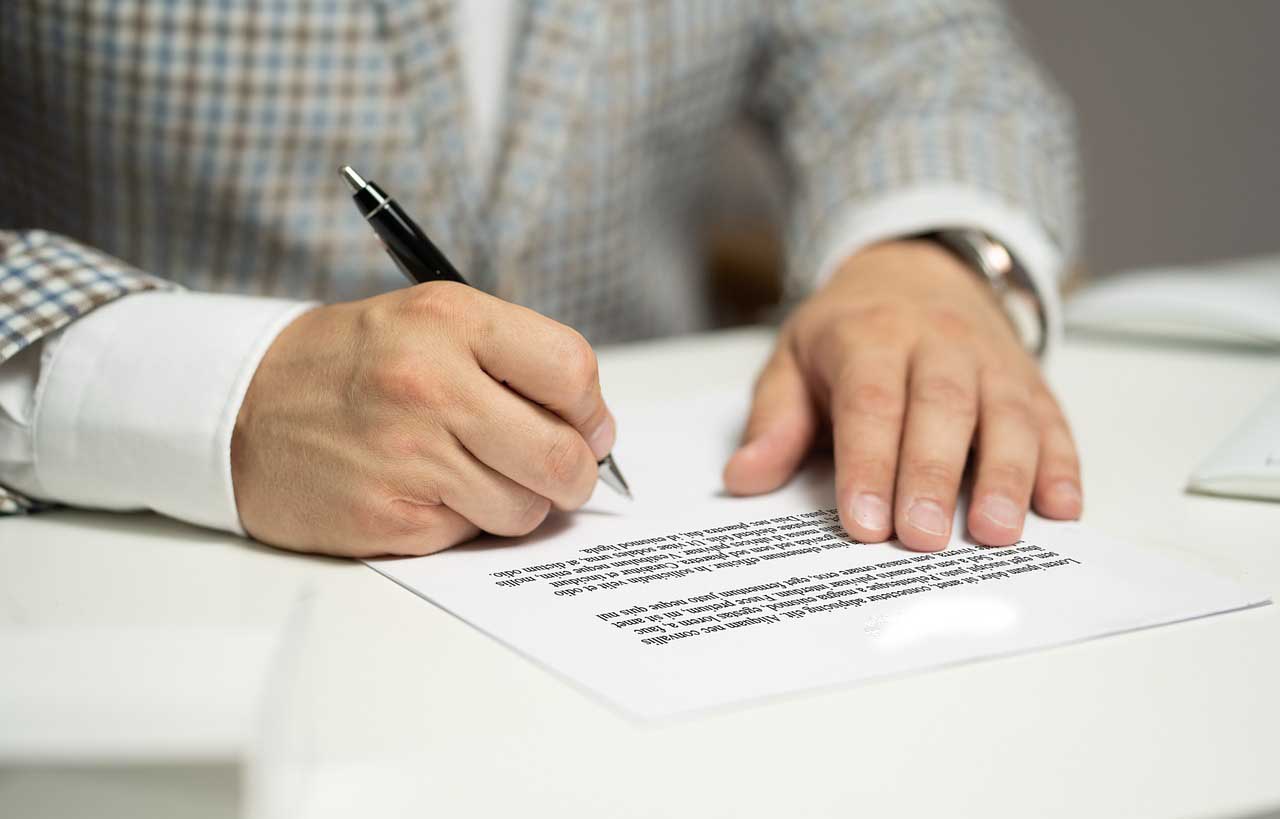 Una personas firmando un documento. Imagen. Pixabay.