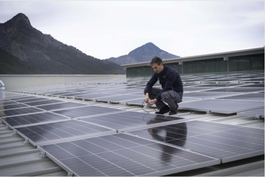 Trabajador de Mercadona en una cubierta de una tienda con paneles solares.