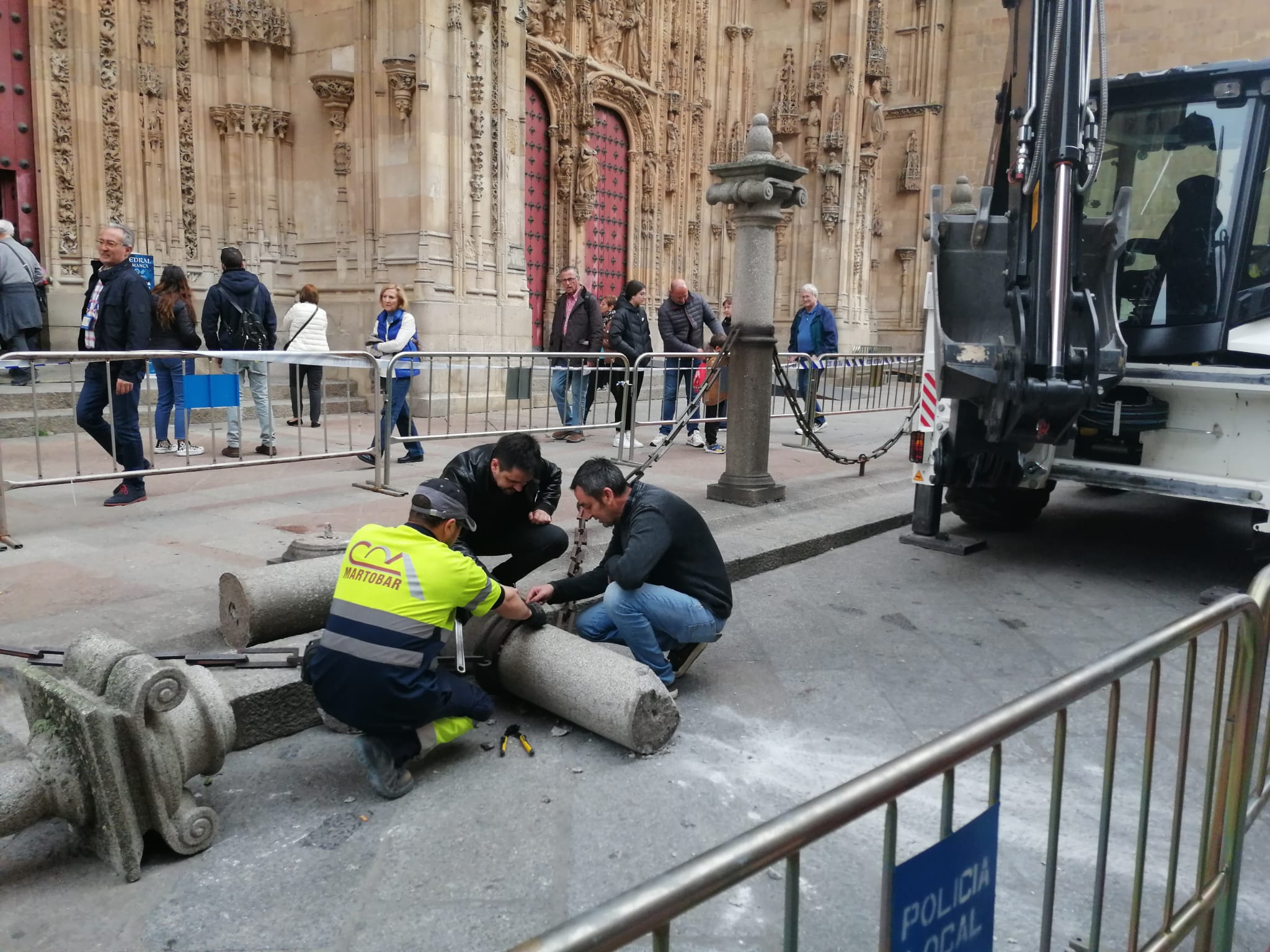 Operarios municipales intentan retirar la columna de la Catedral destrozada.